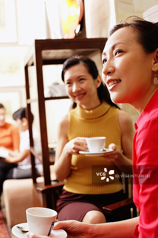 手持杯碟、眺望远方的女士图片素材