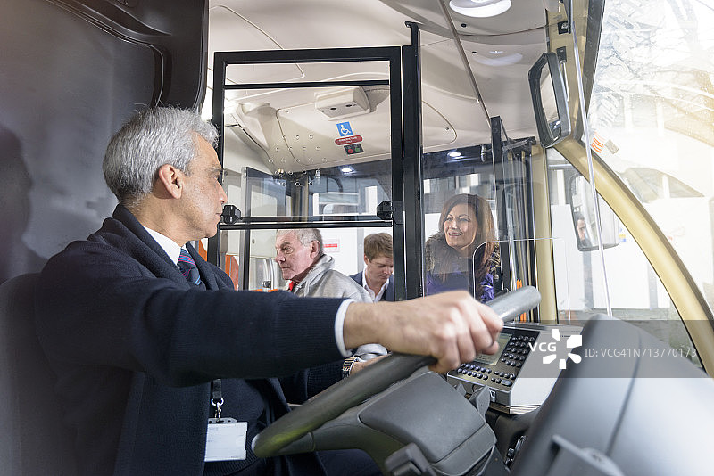 公共汽车司机与乘客登上电动巴士图片素材