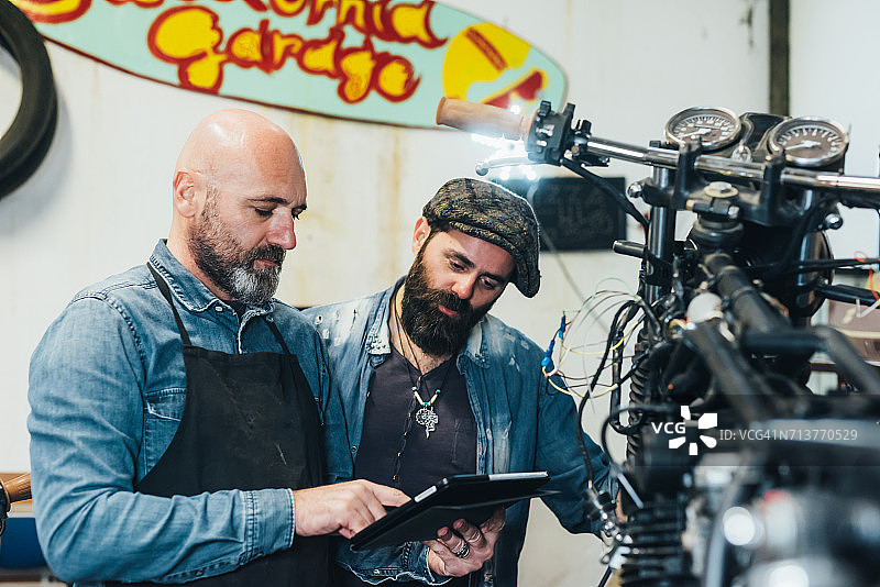 在车库使用平板电脑的两位中年男人图片素材