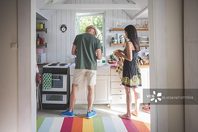 中年夫妇在厨房工作，门口视角图片素材