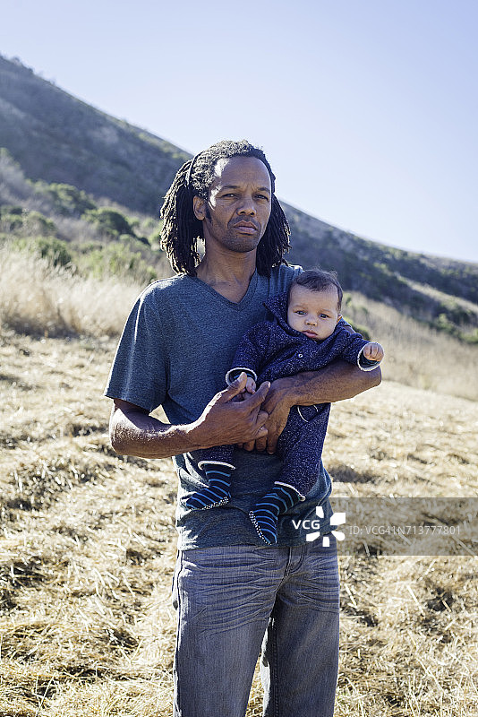 在海滩上抱着男婴的中年男人肖像图片素材