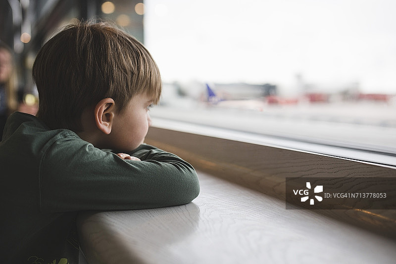 透过餐厅窗户看的男孩图片素材