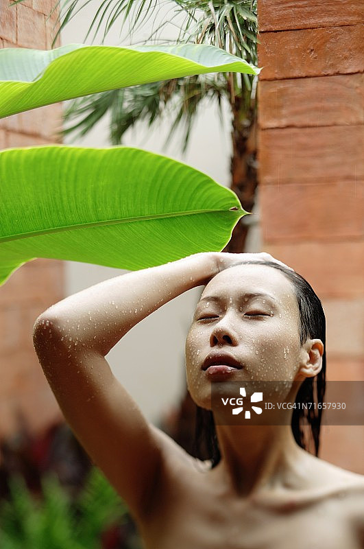 闭着眼睛，在户外淋浴的女人图片素材