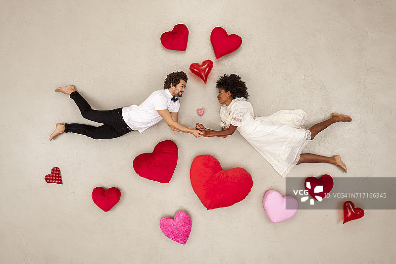 年轻情侣坠入爱河，周围充满爱心图片素材