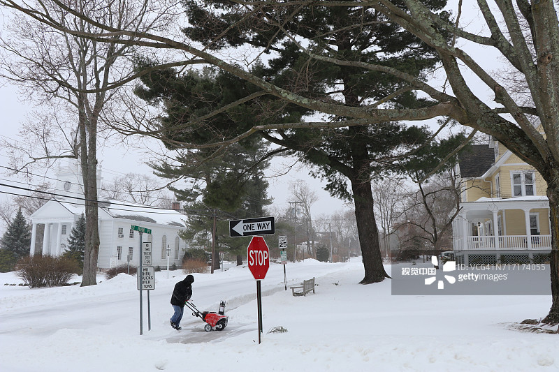 男子在暴风雪中清扫人行道，康涅狄格州图片素材