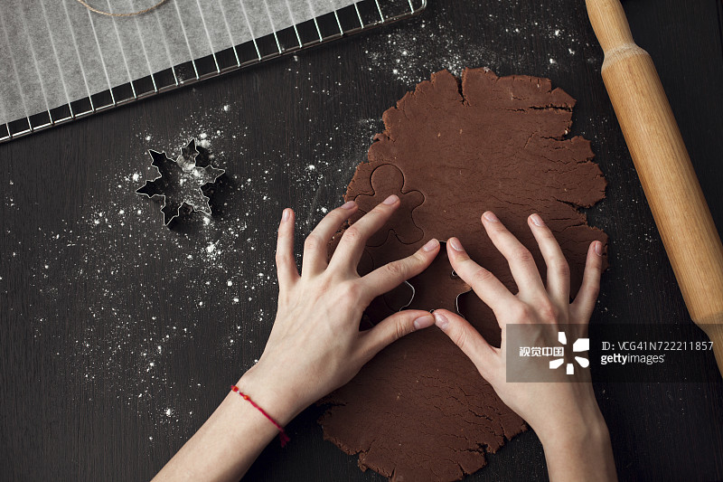 白人女性用糕点刀按压面团图片素材