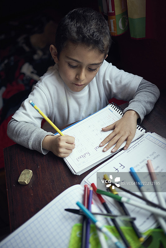 西班牙裔男孩练习写字母图片素材