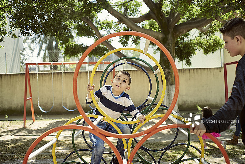 在操场上攀爬设施的西班牙裔男孩们图片素材
