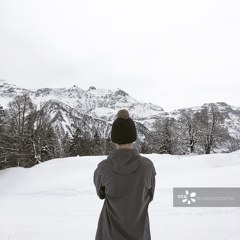 男孩在瑞士布劳恩瓦尔德阿尔卑斯山欣赏风景的背影图片素材