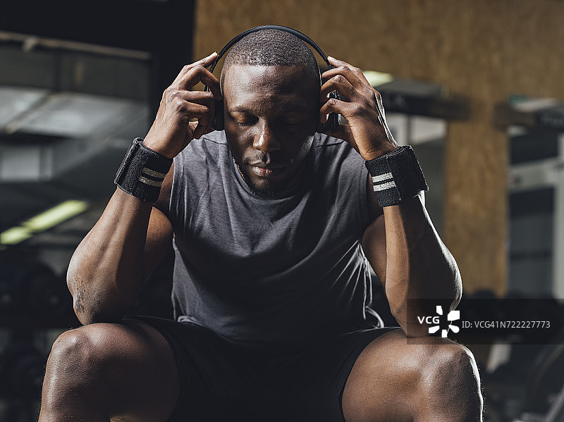 运动员在健身房戴着耳机集中注意力图片素材