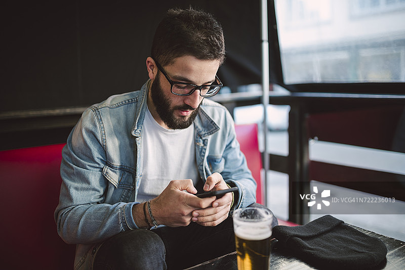 年轻男人在酒吧发短信图片素材