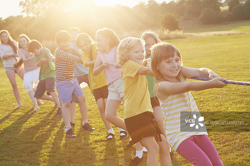 男孩女孩们在运动场上拔河图片素材