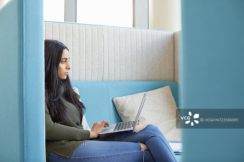 大学生在现代隔间使用笔记本电脑图片素材