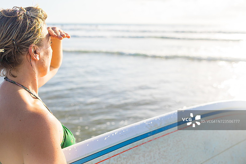 在哥斯达黎加瓜纳卡斯特省诺萨拉海滩上扛着冲浪板眺望大海的女人图片素材