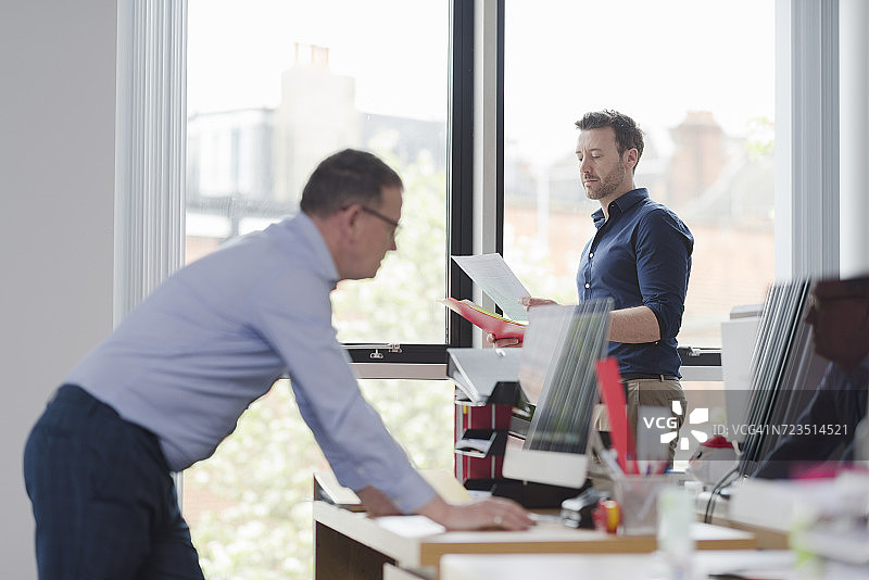 男同事们在办公桌前讨论图片素材