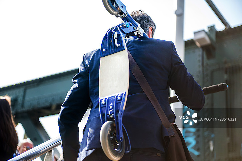 携带滑板车的商人，背景为英国伦敦亨格福德桥图片素材