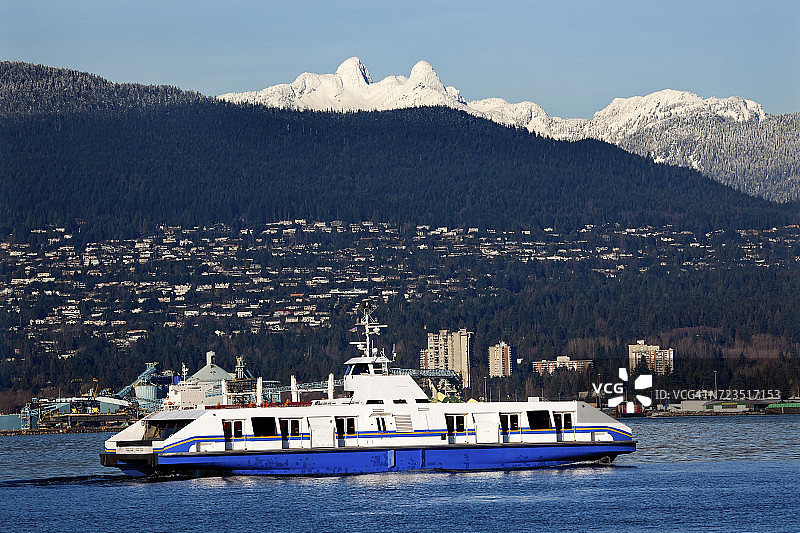 温哥华港的渡轮货轮，背景是加拿大不列颠哥伦比亚省的狮子峰雪山图片素材