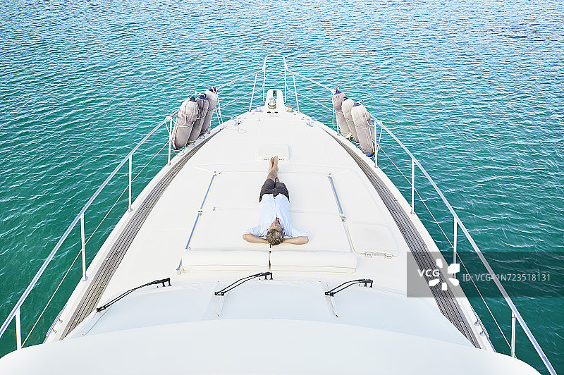 年长的男人躺在他的摩托艇甲板上图片素材