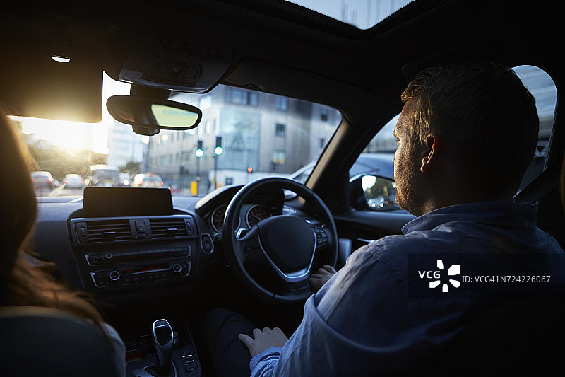 情侣驾车行驶在城市中图片素材