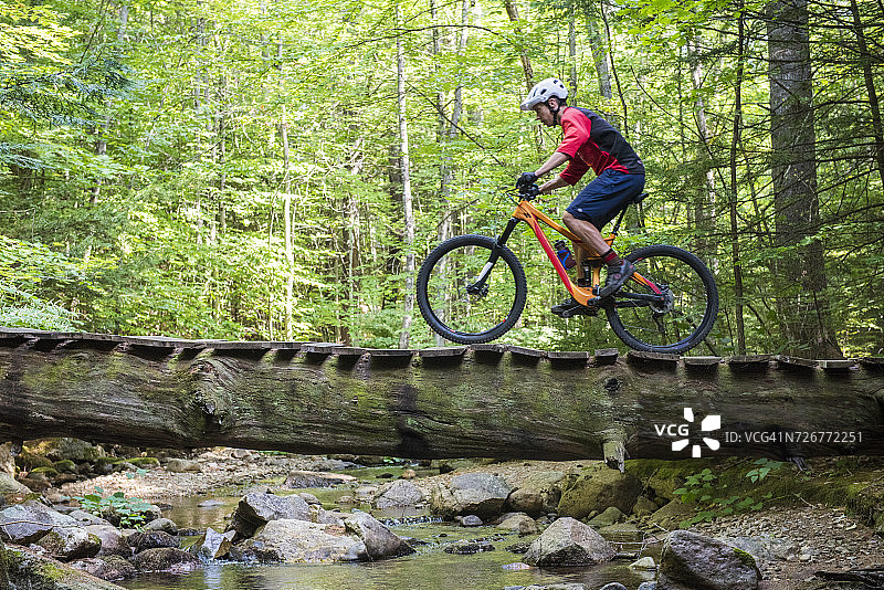 山地自行车手通过松树桥图片素材