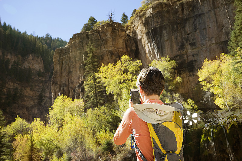 女人徒步时用手机拍照图片素材