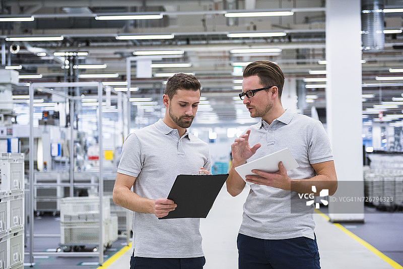 两个男人在工厂车间里交谈图片素材