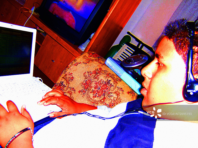 青少年男孩在家用电脑上工作。图片素材