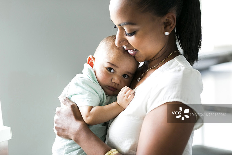 母亲怀抱男婴（2-5个月）的肖像图片素材