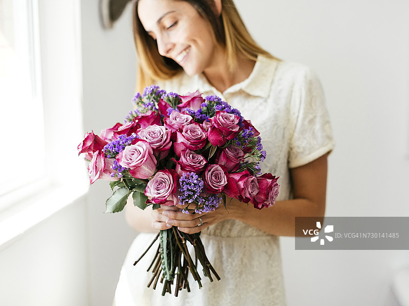 手捧玫瑰花束的女人图片素材
