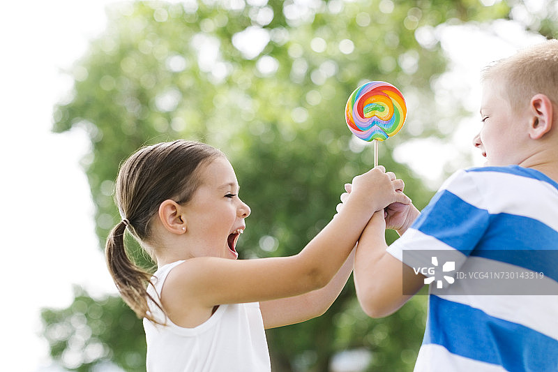 年轻男孩（6-7岁）逗弄妹妹（4-5岁）图片素材