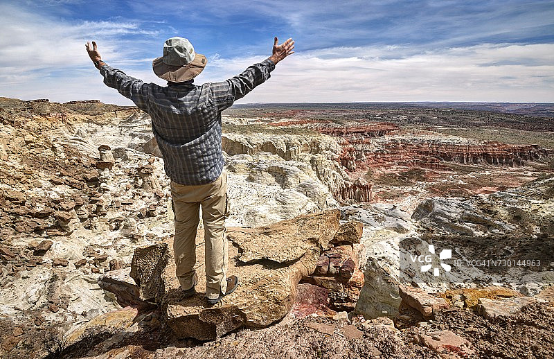 徒步者张开双臂站在美国犹他州大阶梯-埃斯卡兰特国家纪念地的山顶图片素材