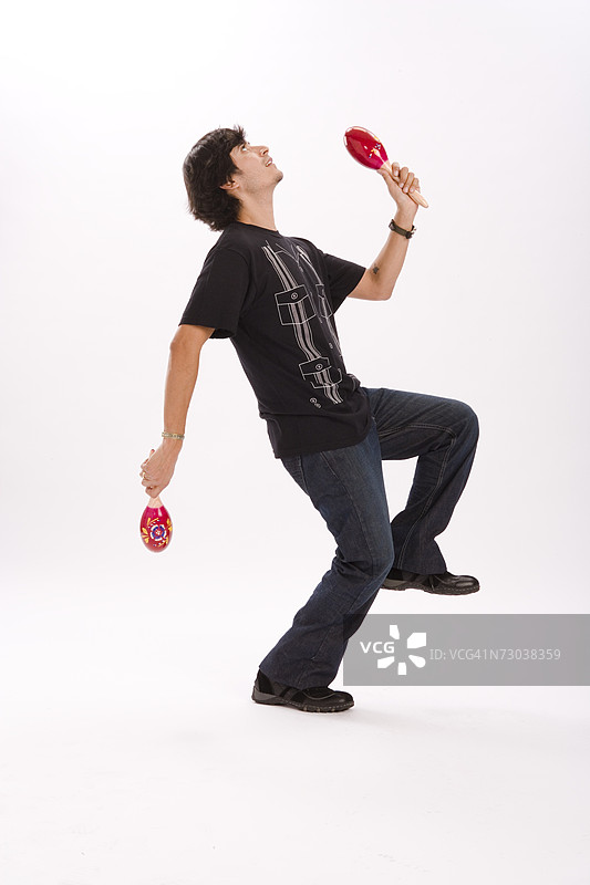 年轻男子跳舞并摇动沙槌的影棚人像图片素材