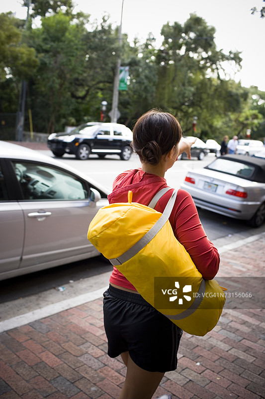 年轻女性提着旅行袋走路图片素材