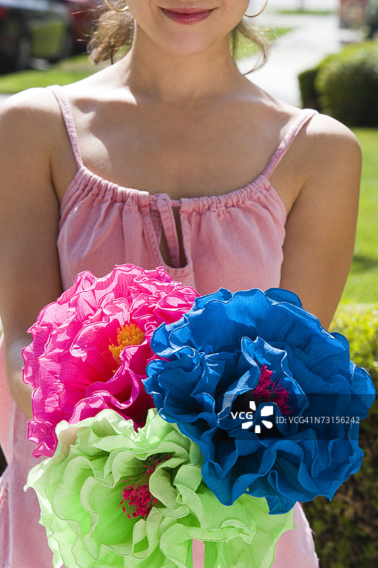 年轻女性手持五彩纸花图片素材