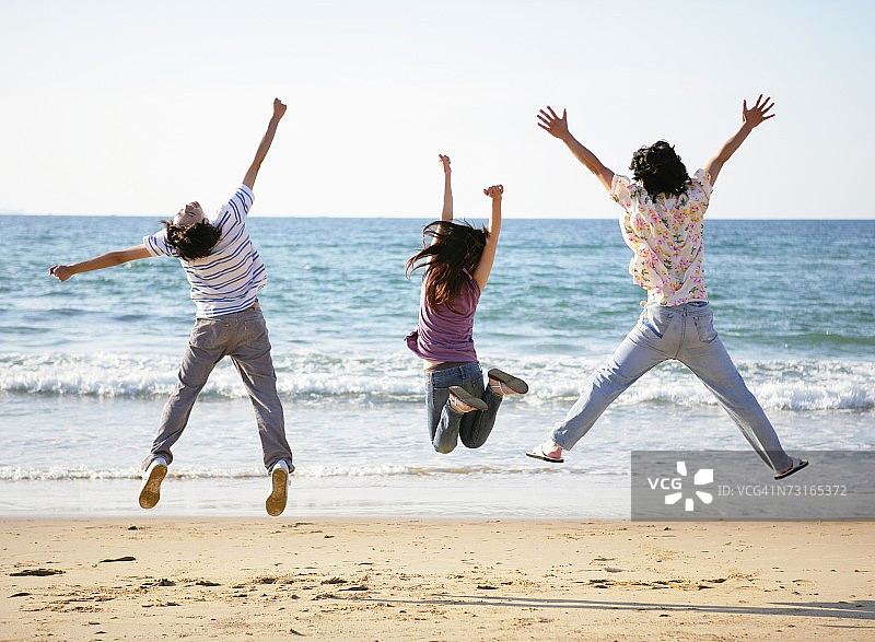 在海滩上跳跃的年轻人图片素材
