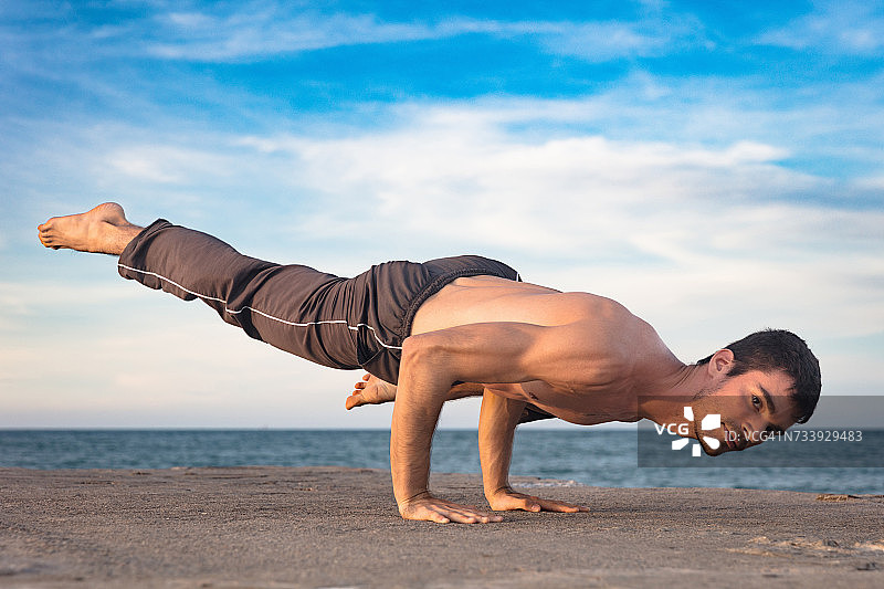 年轻人在户外做瑜伽，用手保持平衡图片素材