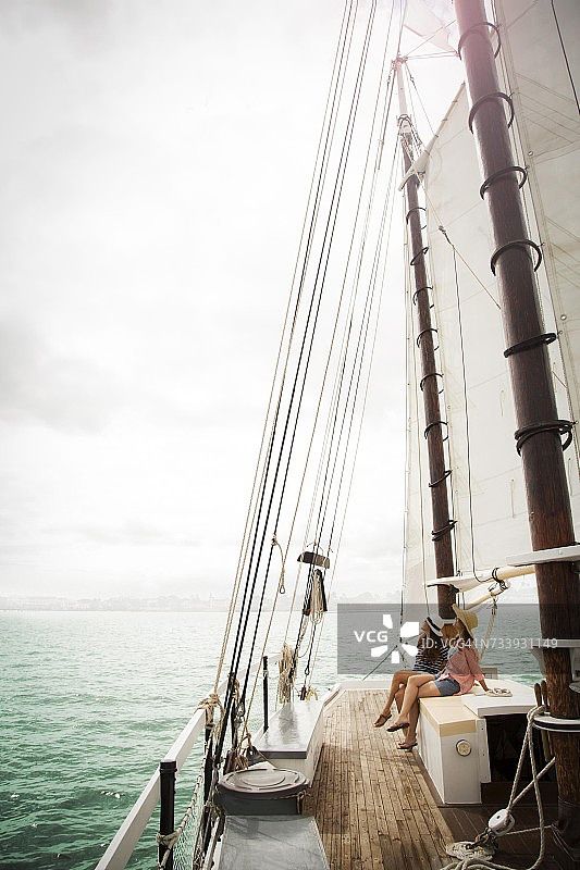 两个女人坐在海上帆船甲板上图片素材
