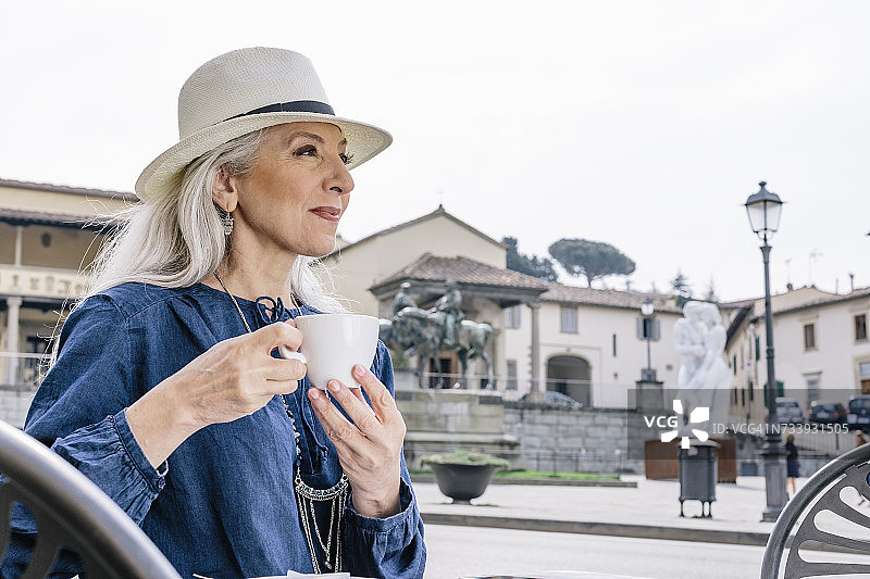 中年妇女在意大利托斯卡纳菲耶索莱的路边咖啡馆喝咖啡图片素材