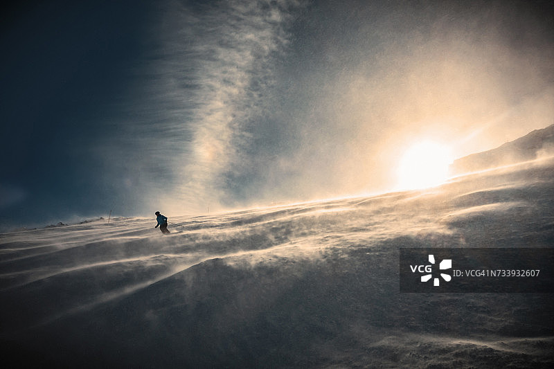 滑雪者在阳光下下坡滑雪，伦策海德，瑞士阿尔卑斯山，瑞士图片素材