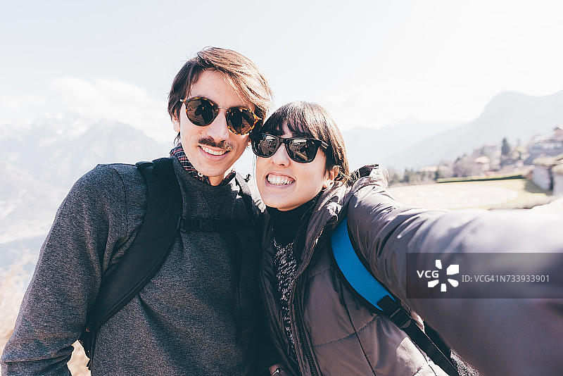 情侣在意大利普里莫山山间湖畔用手机自拍图片素材