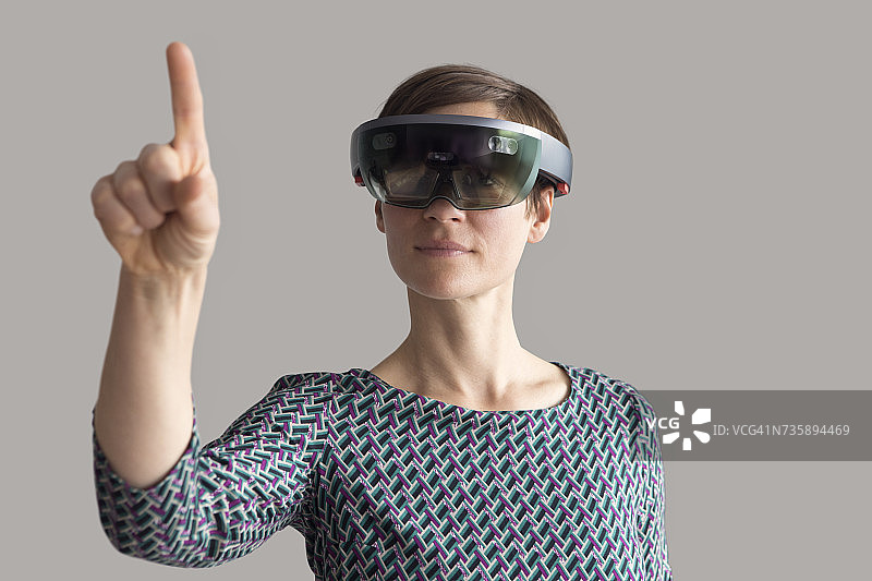 戴着混合现实智能眼镜举手的女人图片素材
