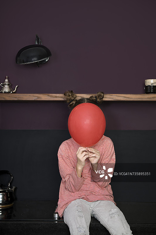 躲在气球后面的厨房女孩图片素材