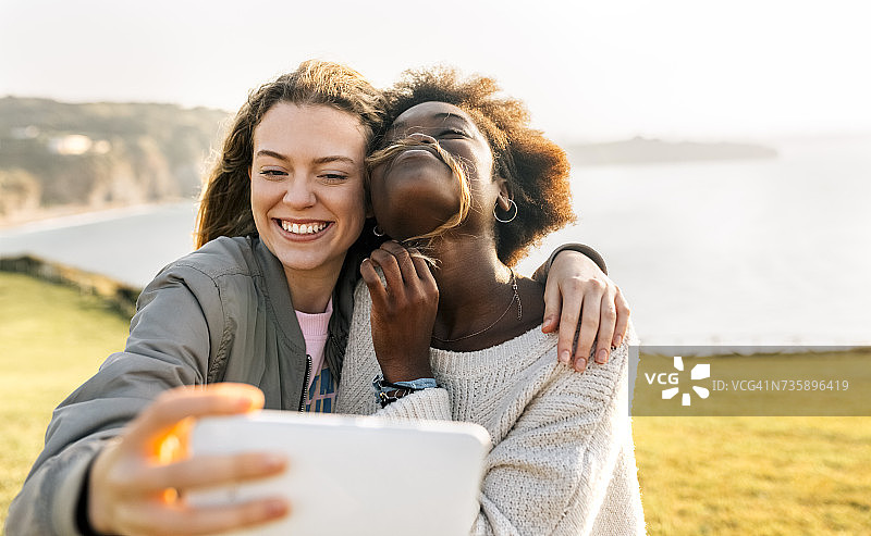 两个快乐的好朋友在海边自拍图片素材