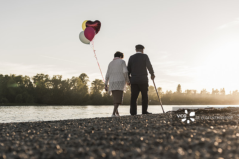 老年夫妇傍晚在河边散步的背影图片素材