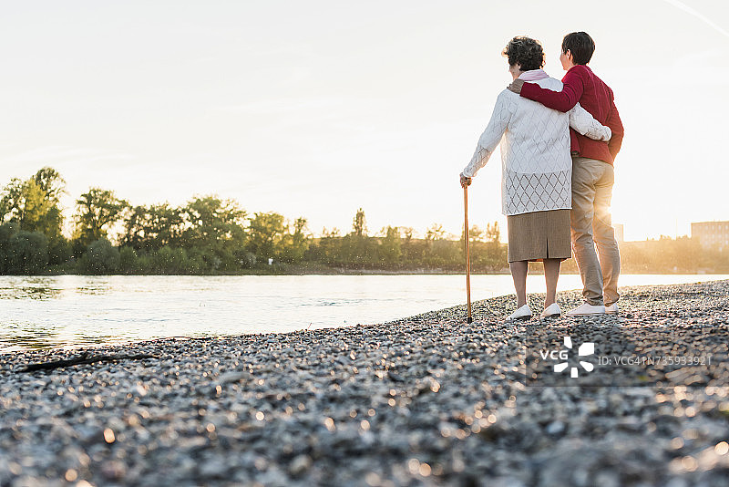 在海滩上手挽着成年女儿的老年妇女背影图片素材