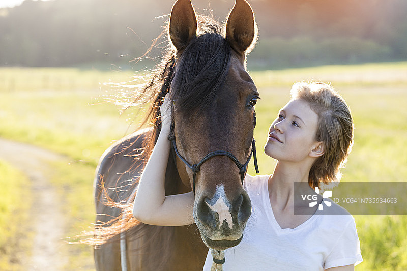 年轻女子与马在自然中图片素材