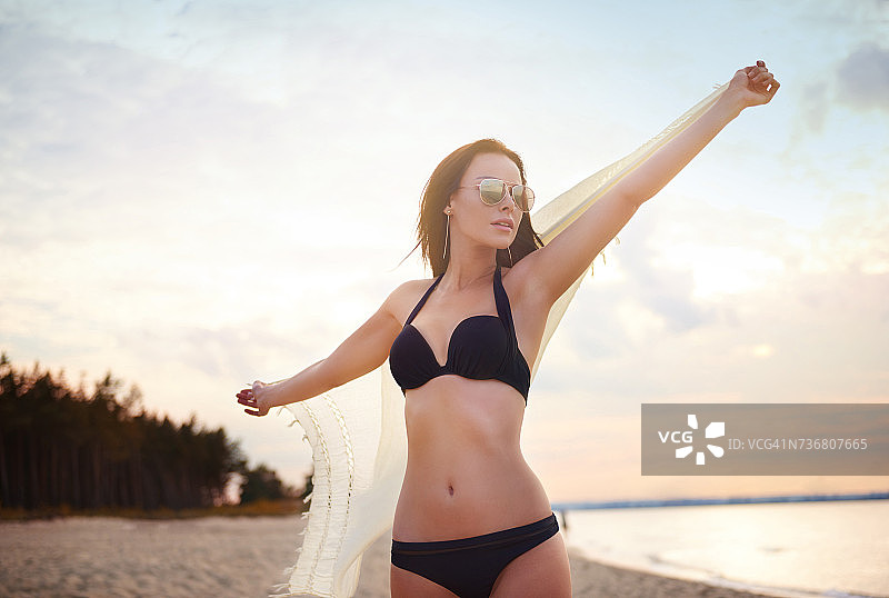 在波兰格但斯克伸展双臂的披白色披肩的女人图片素材