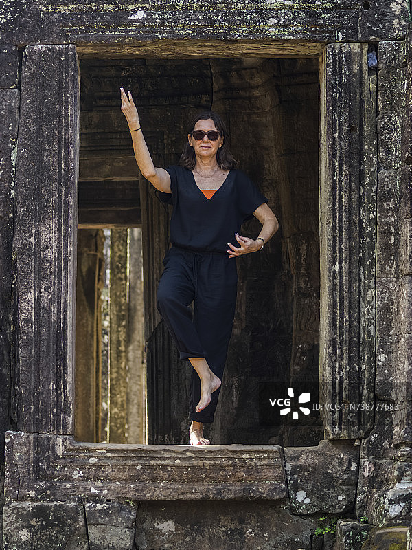 一名女子在吴哥通王城巴戎寺入口处做瑜伽图片素材