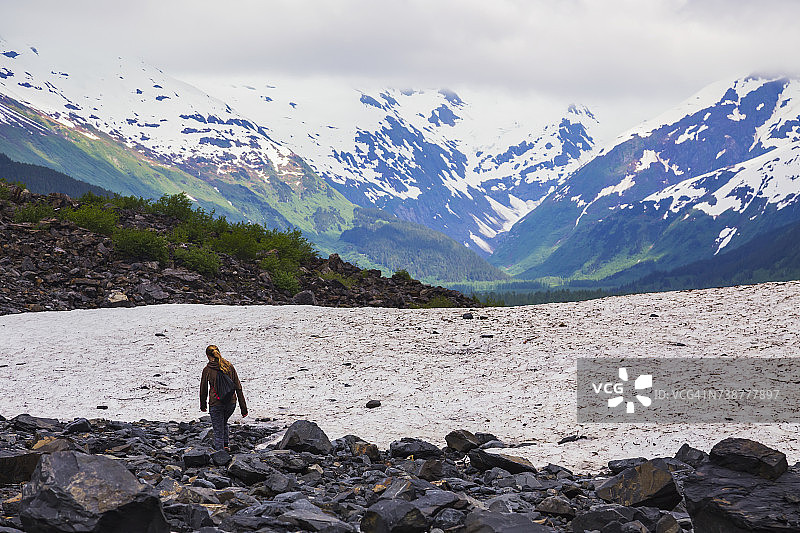 在初夏雨天，少女在波蒂奇山谷拜伦冰川附近的小路上徒步旅行图片素材