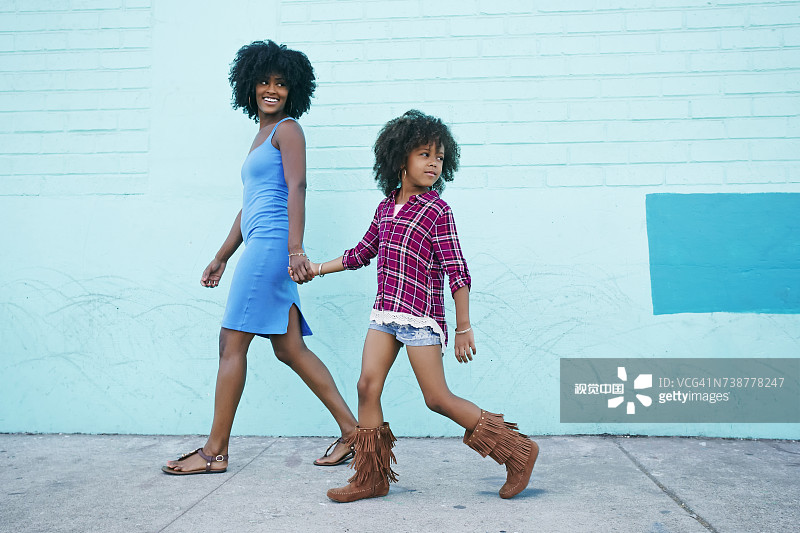 微笑的母女在人行道上行走图片素材